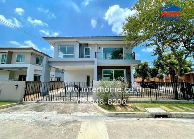 Exterior view of a modern two-story house with a front gate