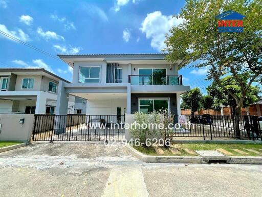 Exterior view of a modern two-story house with a front gate