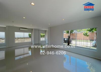 Spacious living room with large windows and tiled floor