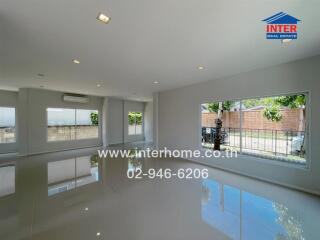 Spacious living room with large windows and tiled floor