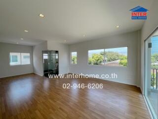 Spacious main living area with wooden floors and large windows with ample natural light