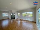 Spacious main living area with wooden floors and large windows with ample natural light