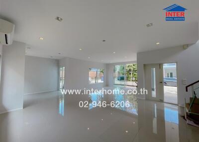 Spacious living area with large windows and tiled flooring