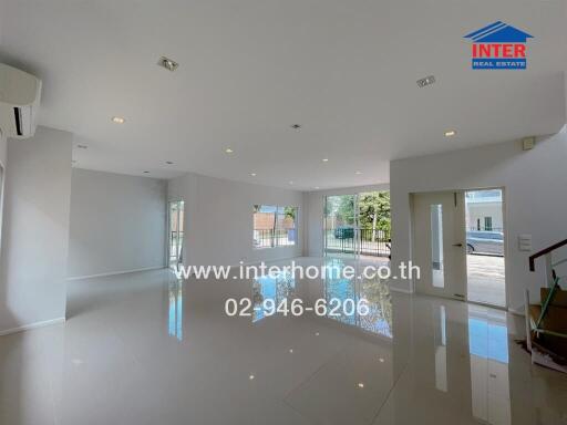 Spacious living area with large windows and tiled flooring