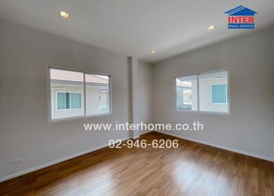 Unfurnished bedroom with hardwood floor and multiple windows