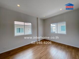 Unfurnished bedroom with hardwood floor and multiple windows