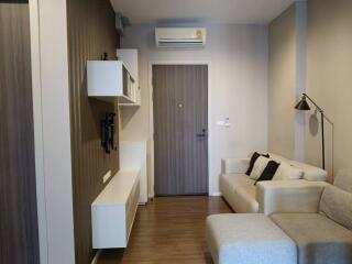 Modern living room with beige sofa and wall-mounted shelves