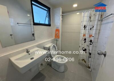 A modern bathroom with a sink, toilet, and shower area