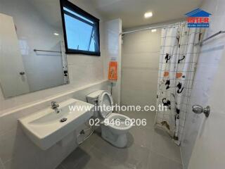 A modern bathroom with a sink, toilet, and shower area