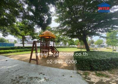 Playground area with slide beneath shade trees