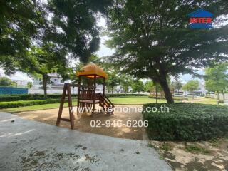 Playground area with slide beneath shade trees