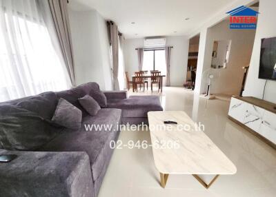 Modern living room with gray sofa and dining area