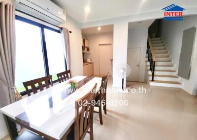 Bright dining area with a window, modern decor, and adjacent stairs.