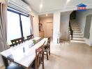 Bright dining area with a window, modern decor, and adjacent stairs.