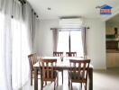 Bright dining room with a dining table and chairs, air conditioner, and large windows with curtains