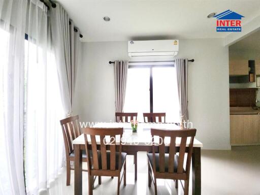 Bright dining room with a dining table and chairs, air conditioner, and large windows with curtains