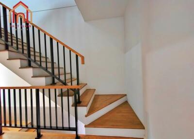 Modern staircase with wooden steps and black railing