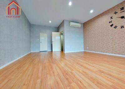 Spacious living room with wooden flooring and wall clock