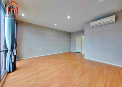 Spacious living room with wooden flooring and large windows