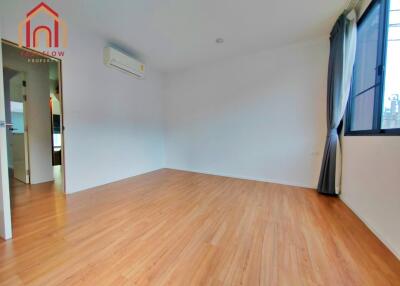 Empty bedroom with wooden flooring and large window