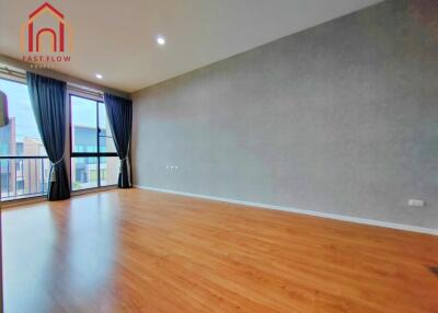 Spacious living room with large window and wooden flooring