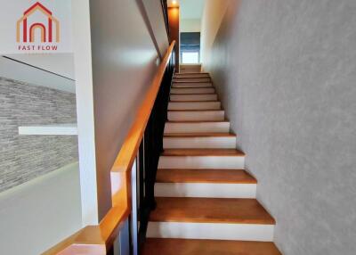 Interior view of a modern staircase with wooden steps and railing