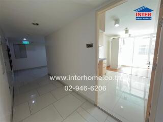 Interior view of an apartment hallway leading into a kitchen