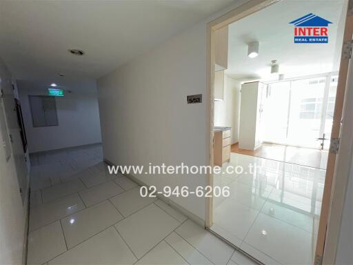 Interior view of an apartment hallway leading into a kitchen