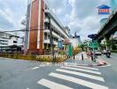 Street view of a building with road signs and logo of real estate company