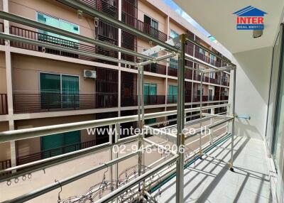 Apartment balcony with metal railings and view of neighboring building