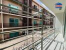 Apartment balcony with metal railings and view of neighboring building