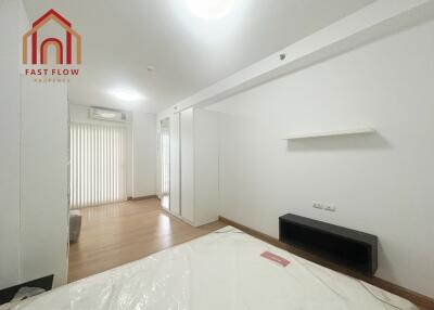 Spacious and bright bedroom with wooden flooring and ample storage