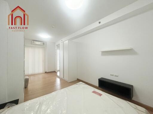 Spacious and bright bedroom with wooden flooring and ample storage