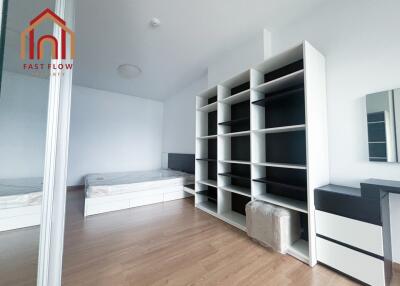 Modern bedroom with wooden flooring and built-in shelves