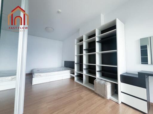 Modern bedroom with wooden flooring and built-in shelves