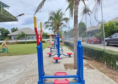 Outdoor fitness area with exercise equipment and palm trees