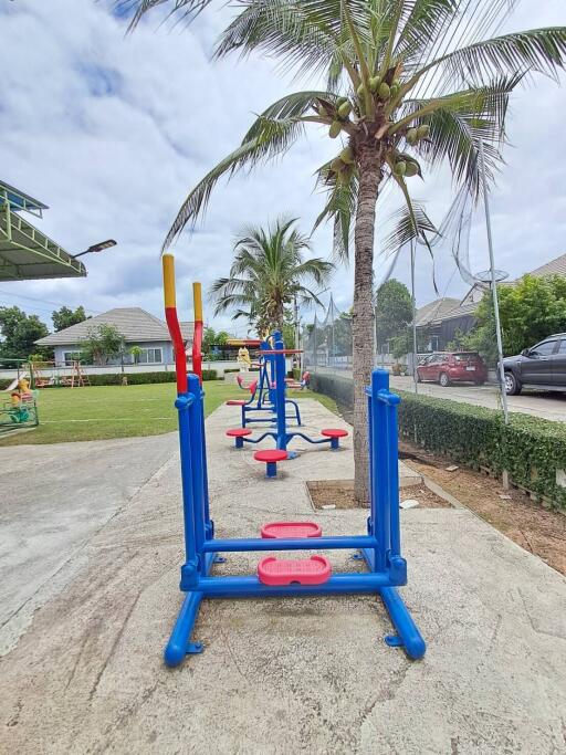 Outdoor fitness area with exercise equipment and palm trees