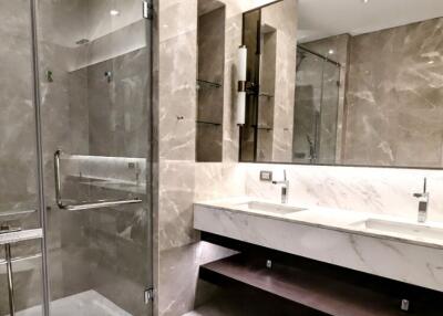 Modern bathroom with dual sinks, glass shower and marble finishes