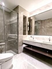 Modern bathroom with dual sinks, glass shower and marble finishes