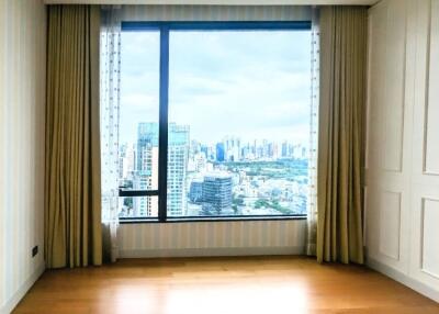 Spacious bedroom with a large window offering a city view