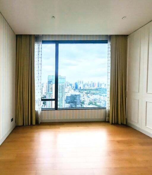 Spacious bedroom with a large window offering a city view