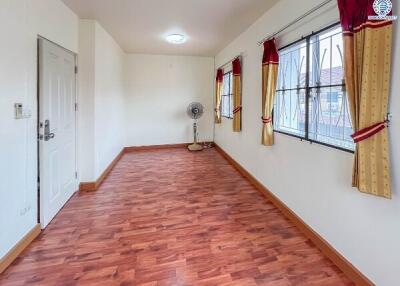 Spacious living room with wood flooring and large windows