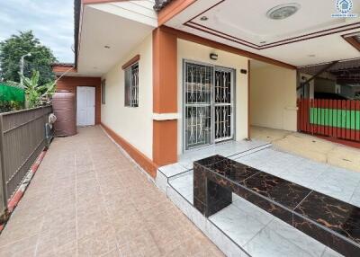 Exterior view of the property with a side walkway and covered porch