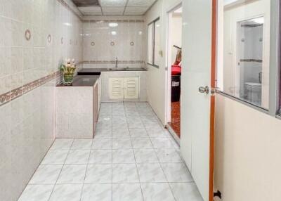 Spacious kitchen with tiled flooring and countertops