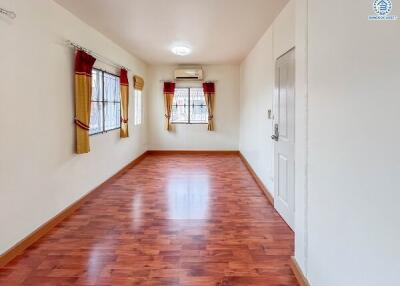 Spacious living room with wooden flooring and large windows