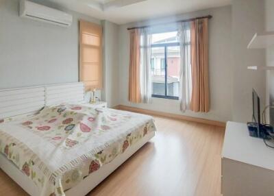 Bedroom with wooden flooring, natural light, and air conditioning