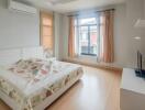 Bedroom with wooden flooring, natural light, and air conditioning