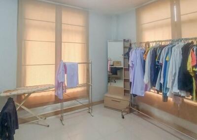 Bedroom with clothing racks and ironing board