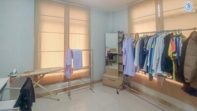 Bedroom with clothing racks and ironing board