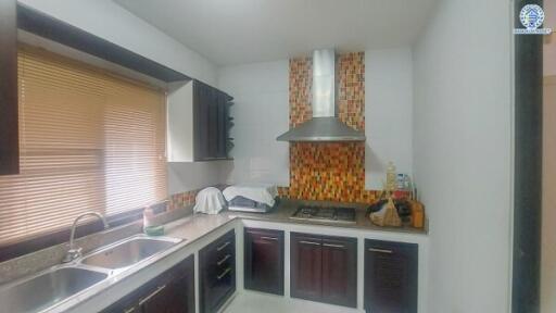 Modern kitchen with dark wood cabinets and mosaic tile backsplash